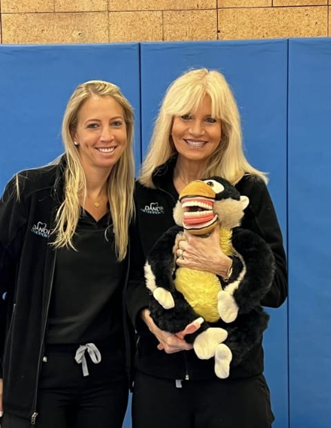 Dr. Danoff holding a stuffed monkey with human teeth in its mouth